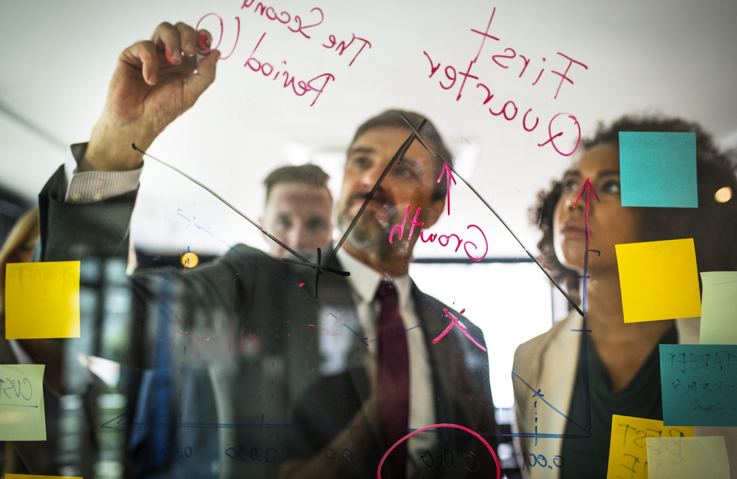 Businesspeople planning on a glass wall